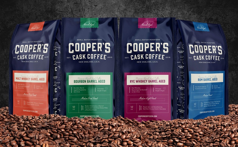 photo of 4 bags of cooper's barrel aged coffee on mound of beans as one way how to store coffee beans