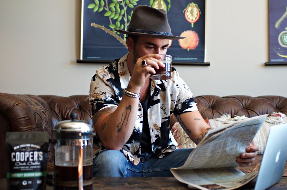 Dad enjoying coffee and a paper showing that Cooper's Cask Coffees make good fathers day gift ideas