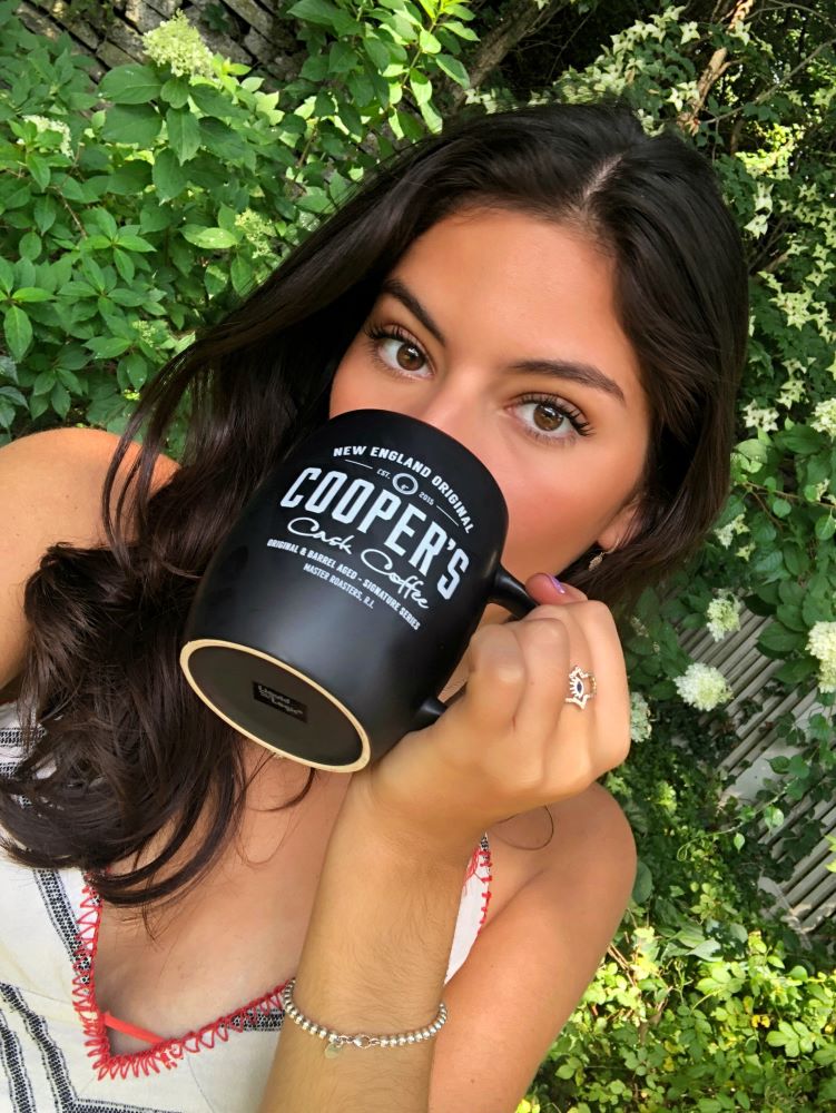 Portrait of a beautiful young woman against a garden background drink Cooper's Craft coffee inspired coffee cocktails