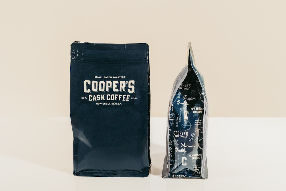 cooper's cask coffee bags on a white table with a beige background showing retailers how cooper's works as wholesale coffee suppliers